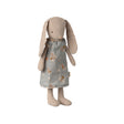 A soft Maileg bunny wearing a charming grey dress adorned with delicate floral patterns.