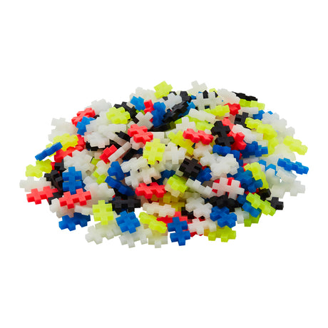 A pile of Plus-Plus building pieces in glow-in-the-dark, neon, and classic colours.