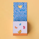 Opened game box revealing a colourful floral pattern and a chick illustration.