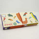 Kitpas Ecru Crayons 12-pack in a beautifully illustrated box featuring hand-drawn birds, with a red elastic band securing the packaging.