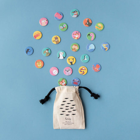 Fabric storage pouch for Lotto Habitats game – A drawstring pouch with a fish pattern and black ties, surrounded by scattered animal tokens.