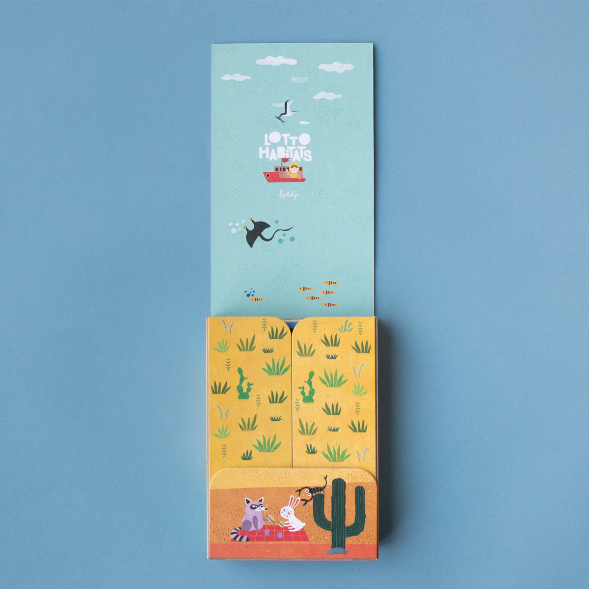 Opened Lotto Habitats game box with illustrated insert – The game’s box opened to reveal a colourful interior with an illustrated desert scene.