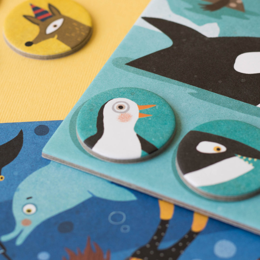 Penguin token placed on a sea-themed board – A game token featuring a penguin placed on a habitat board with ocean animals.