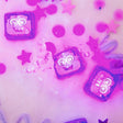 A set of glowing Lumi purple Glo Pals light-up cubes submerged in water, surrounded by pink stars and floating sensory elements.