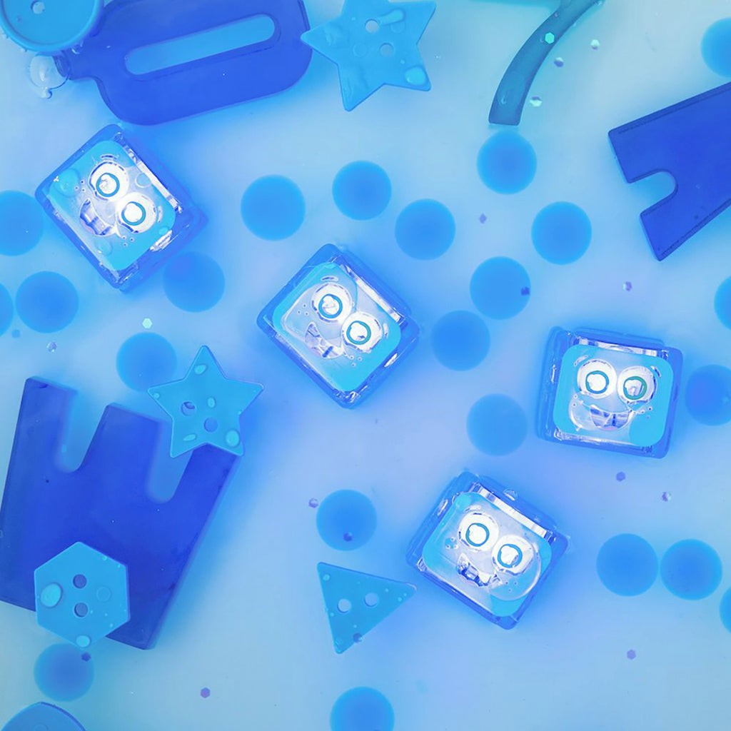 Blue Blair Glo Pals light-up sensory cubes submerged in water with floating blue geometric shapes and circles.