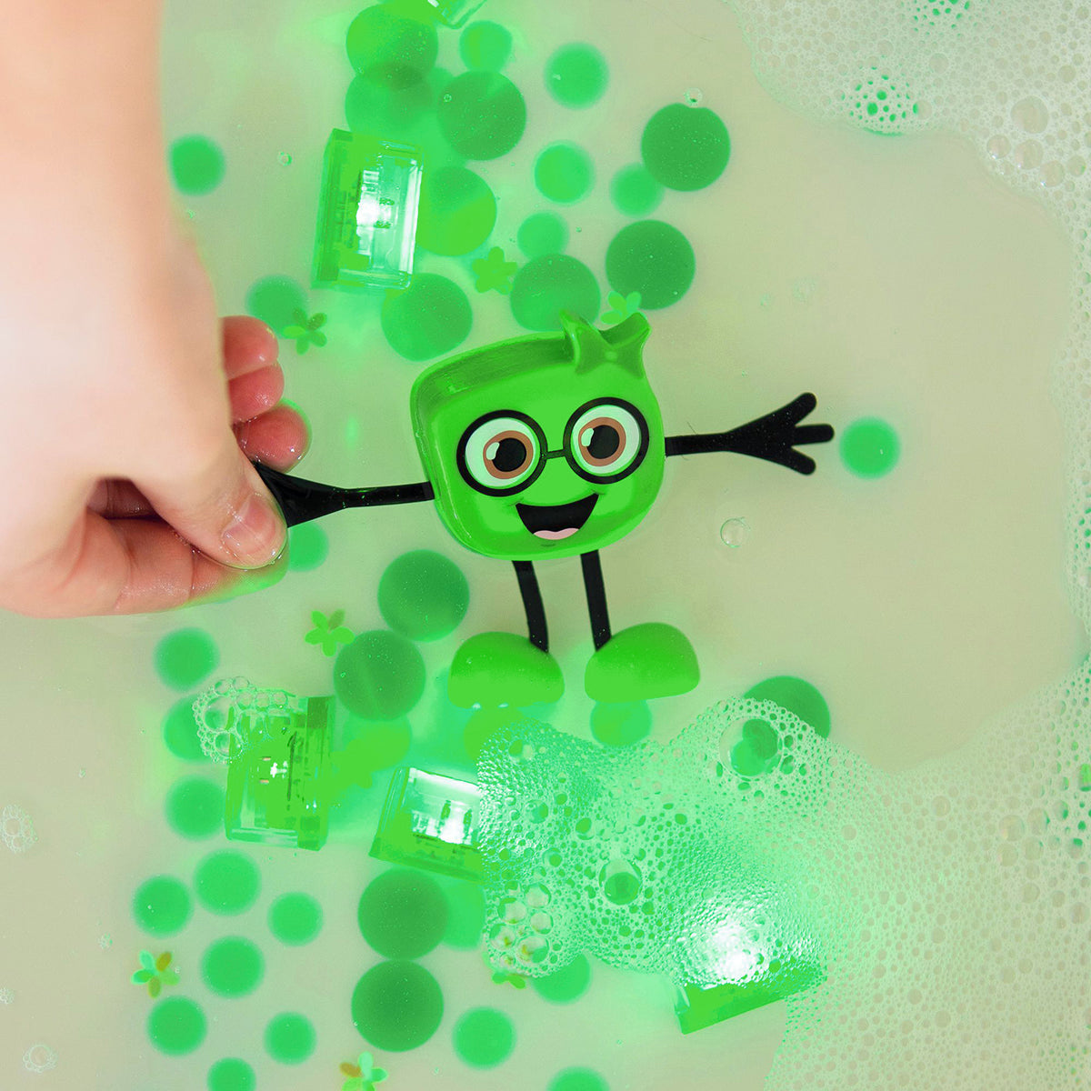 Green Glo Pals Pippa character and light-up cubes glowing in water with floating bubbles and foam.