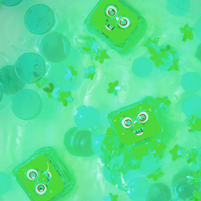 Green Pippa Glo Pals light-up sensory cubes floating in water with green decorative elements.