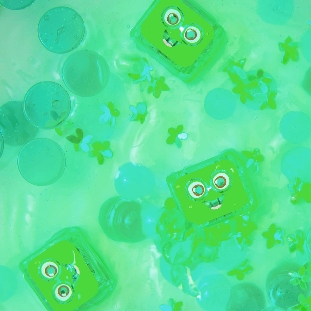 Green Pippa Glo Pals light-up sensory cubes floating in water with green decorative elements.