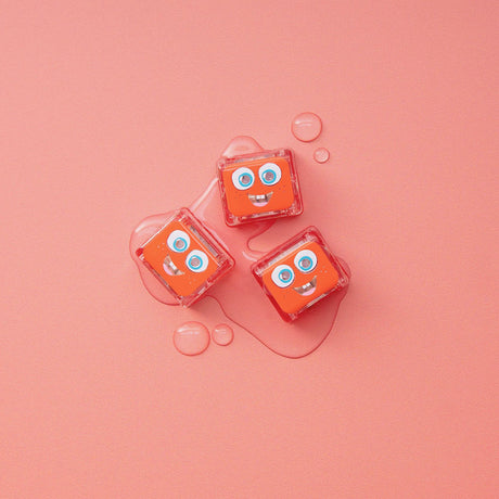 Three Glo Pals Sammy light-up cubes on a pink background with water droplets