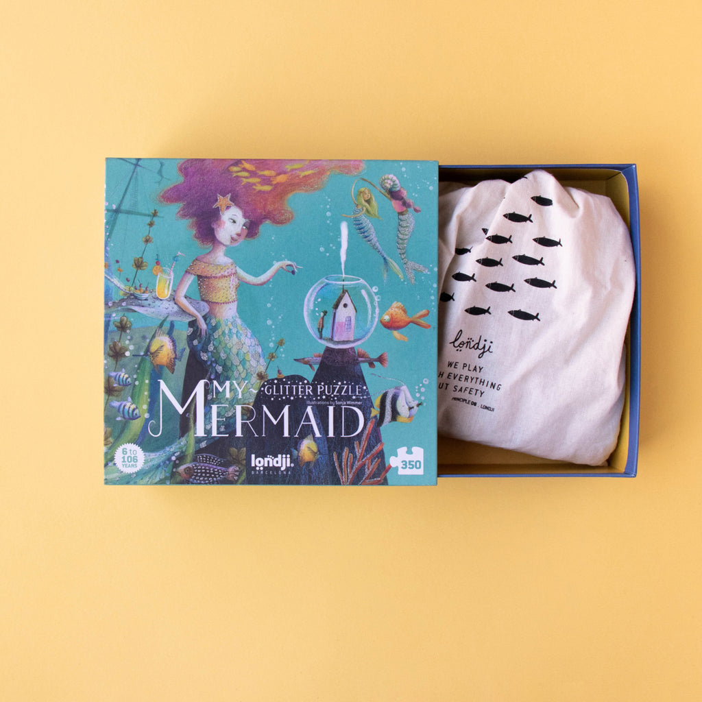 The Londji My Mermaid puzzle box opened to reveal a fabric storage bag with fish illustrations.