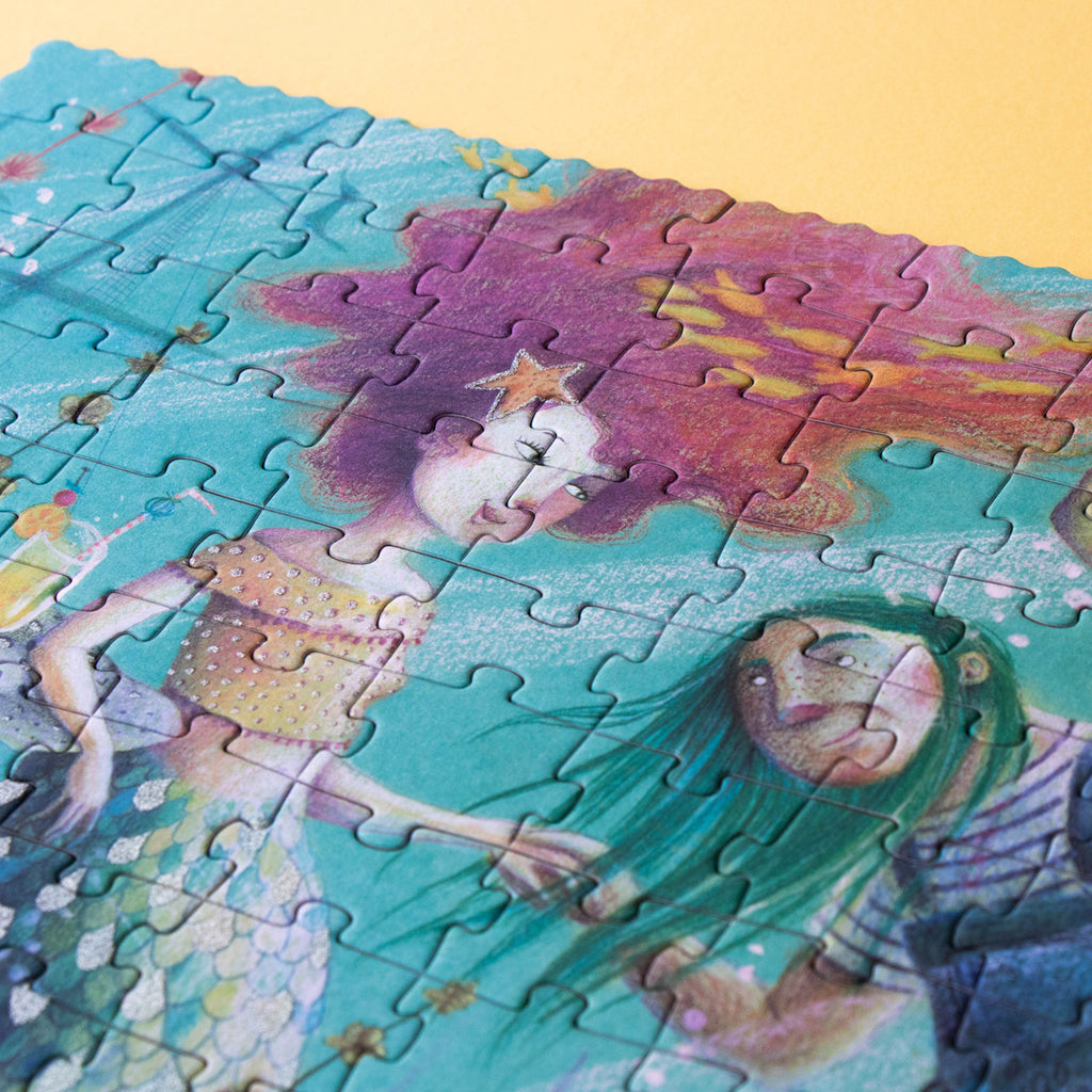 A close-up of a mermaid illustration on the puzzle, showing glitter details in her flowing pink hair.