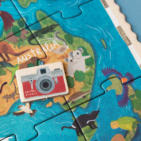 A detailed view of an Animal Planet puzzle section showing a red camera token on an illustrated map of Australia, featuring koalas, kangaroos, and other native wildlife
