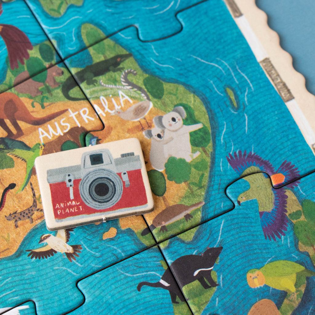 A detailed view of an Animal Planet puzzle section showing a red camera token on an illustrated map of Australia, featuring koalas, kangaroos, and other native wildlife