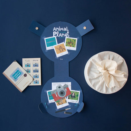 The open packaging of the Animal Planet puzzle, showing a notebook and fabric storage bag.