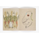 Open book page featuring embroidered artwork of foliage and an elephant head next to "E is for Elephant".