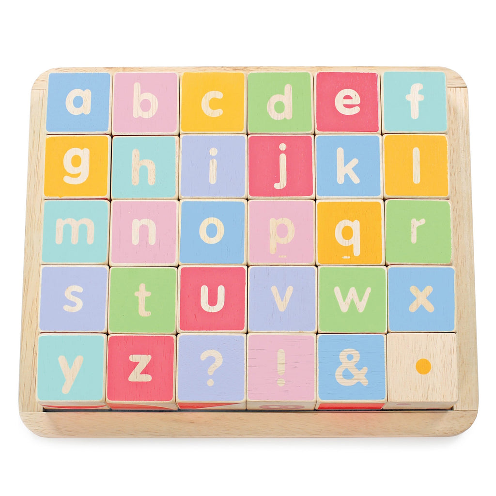 Colorful wooden letter blocks arranged in a grid, featuring lowercase letters, punctuation marks, and a wooden tray.