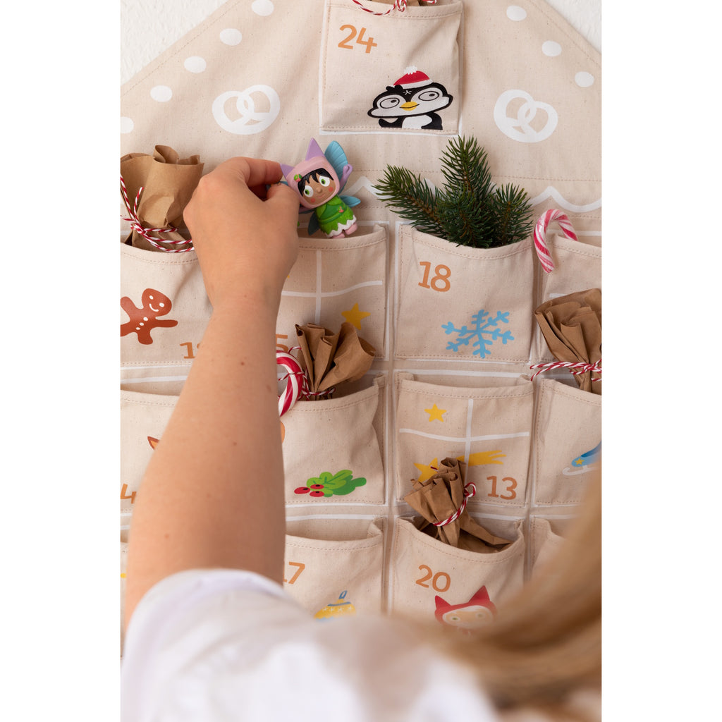 A festive fabric advent calendar with numbered pockets, featuring cheerful holiday-themed illustrations and a house-shaped design.