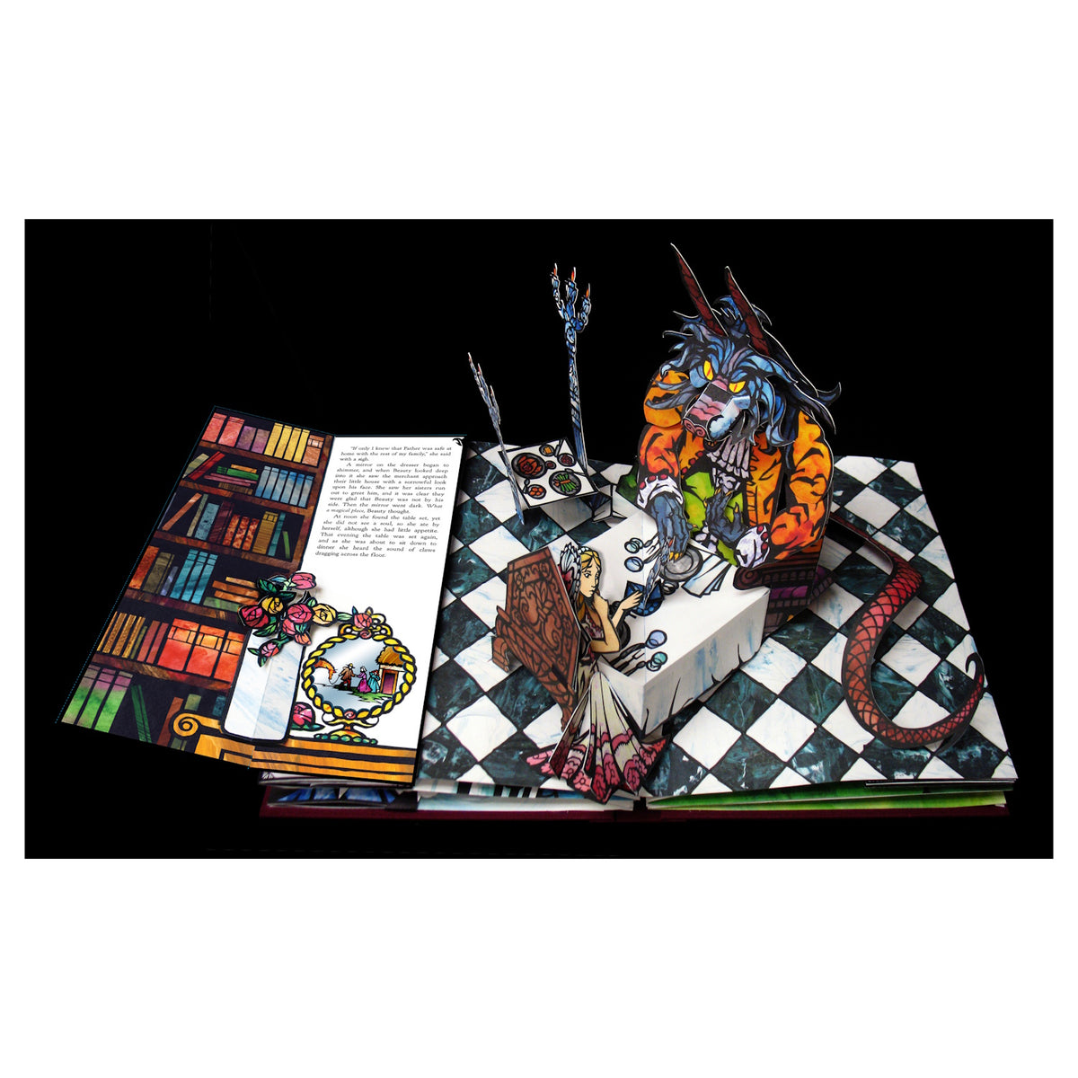 Pop-up book scene with a beastly figure in an orange coat sitting at a table across from a woman. Checkered floor and illustrated book and crown.