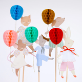 Close-up view of illustrated animal cake toppers with 3D honeycomb paper balloons.
