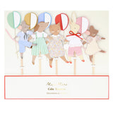 Packaging for Meri Meri cake toppers featuring dressed animal figures holding colorful balloons.