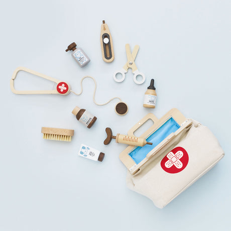 Wooden vet play set with stethoscope, syringe, and medical accessories around an open canvas bag.