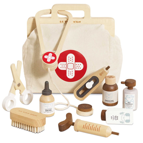 Wooden toy animal vet kit with a canvas medical bag, stethoscope, syringe, brush, and accessories.