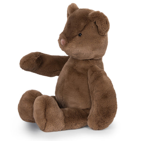 A brown, plush teddy bear sitting in profile against a white background with its arm extended forward.