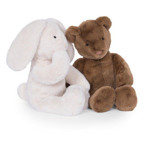 A plush white bunny sitting next to a plush brown teddy bear against a white background.