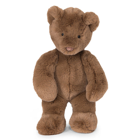 A medium brown, fuzzy teddy bear with small black eyes and a pinkish-brown nose standing against a white background.