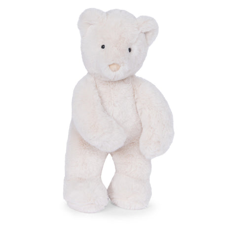 A fluffy, cream-colored teddy bear standing upright against a white background with small black eyes and a tan nose.