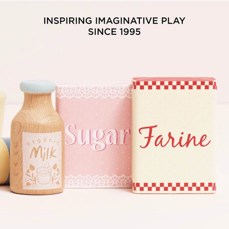 Wooden toy accessories including a milk bottle, pink sugar box, and Farine flour box.
