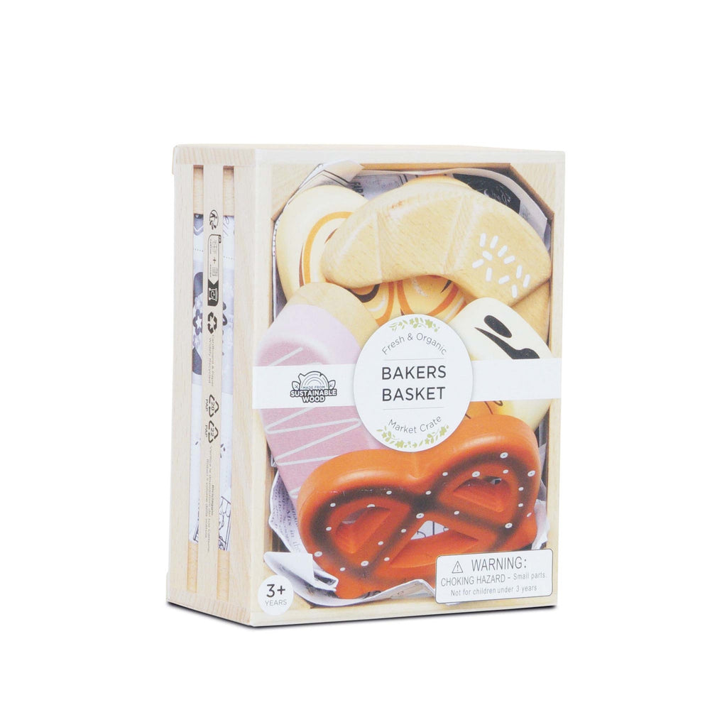 Wooden toy bakery set in a crate with croissants, pretzels, and pastries. Label reads "Bakers Basket". Design is playful and colorful.
