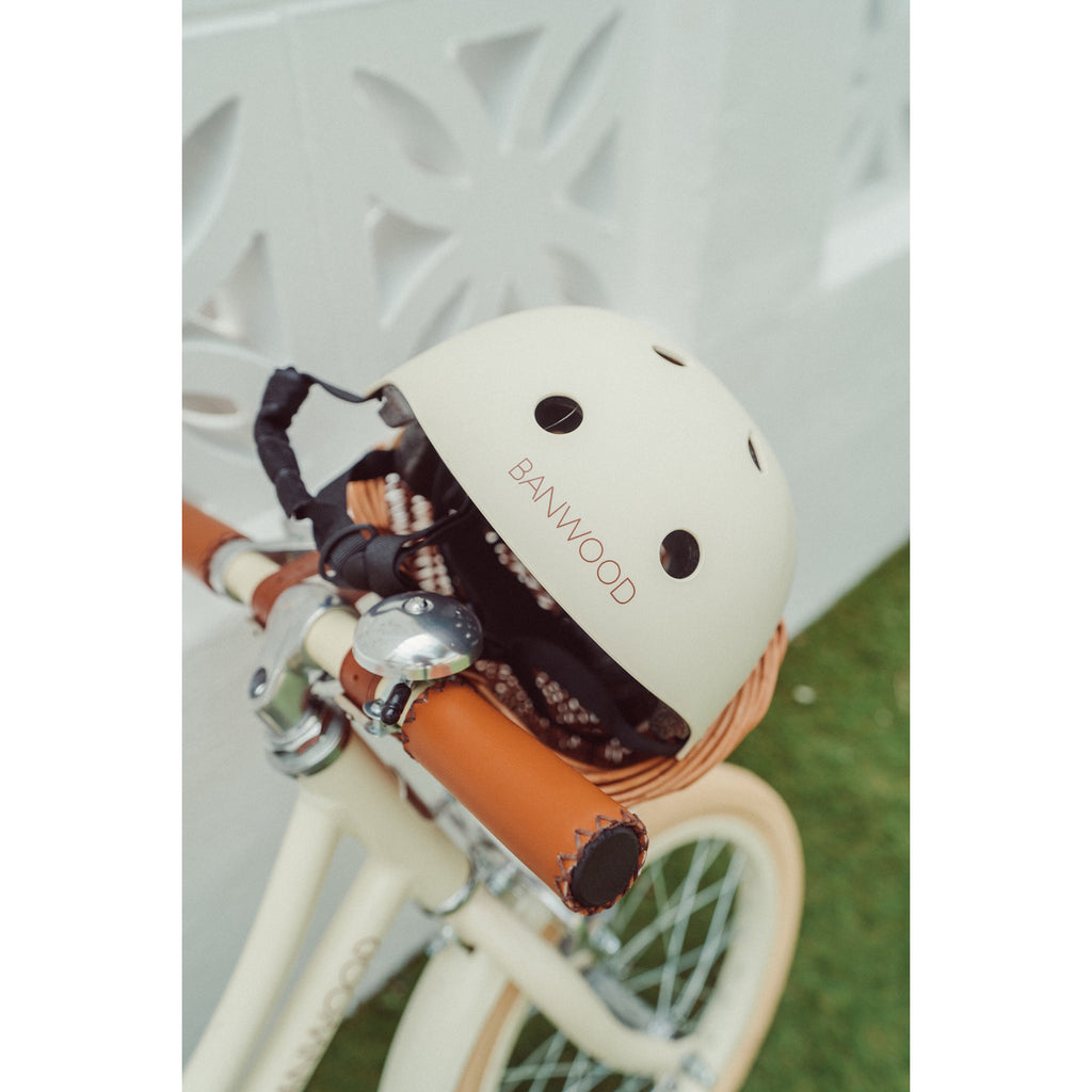A stylish and durable kids’ bike helmet in a soft cream color, featuring an adjustable chin strap and ventilation for safety and comfort.