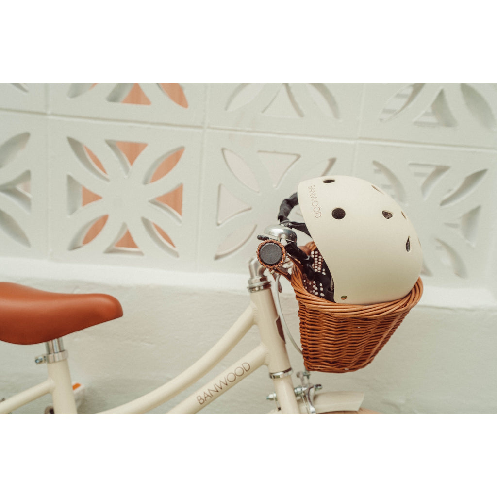 A stylish and durable kids’ bike helmet in a soft cream color, featuring an adjustable chin strap and ventilation for safety and comfort.