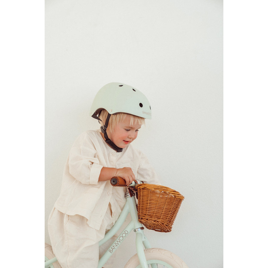 A vintage-inspired kids' bike helmet in a pale mint green shade, designed with ventilation, adjustable straps, and a secure fit for safety and comfort.