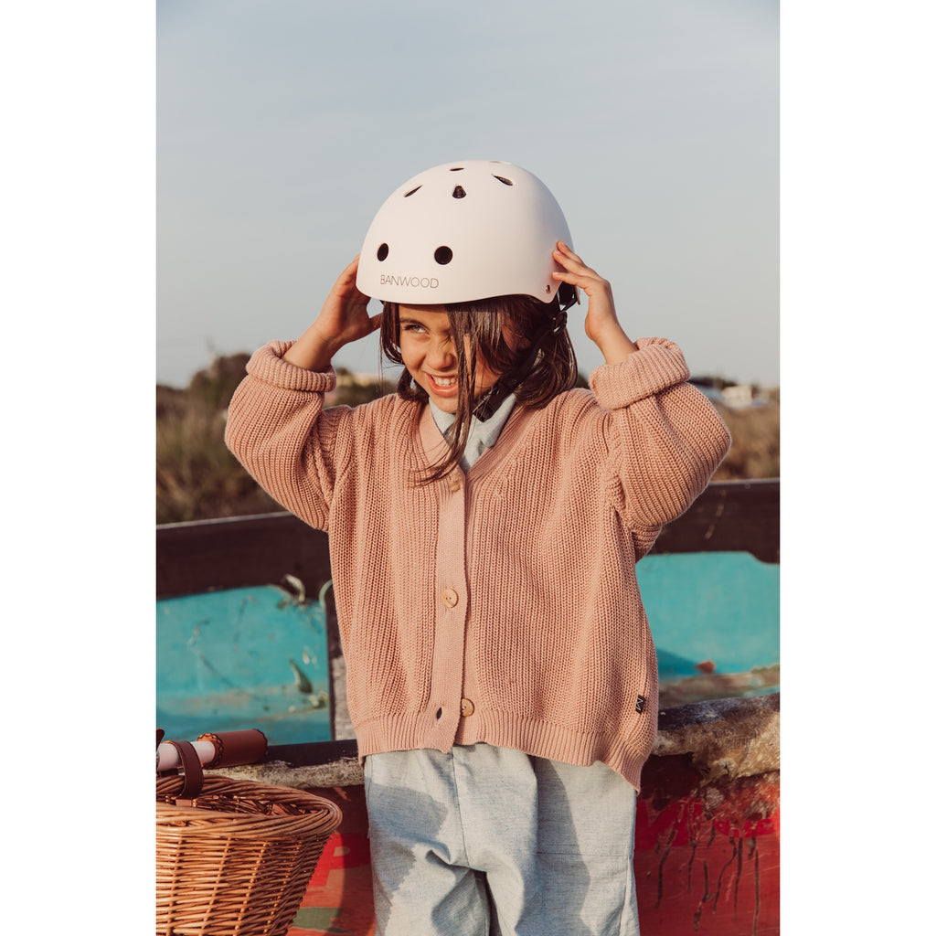 A sleek and safe children’s bike helmet in a pink finish, featuring ventilation holes, an adjustable fit system, and a secure chin strap.