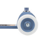 Banwood scooter blue front wheel close-up showing white rubber tire, blue hub, and silver metal bearing detail.