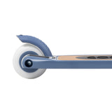 Banwood scooter blue rear wheel close-up showing white tire, blue fender brake, and natural wood deck detail.