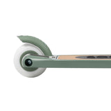 Close-up view of the rear white wheel, brake, and wooden deck of a sage green kids scooter on a white background.