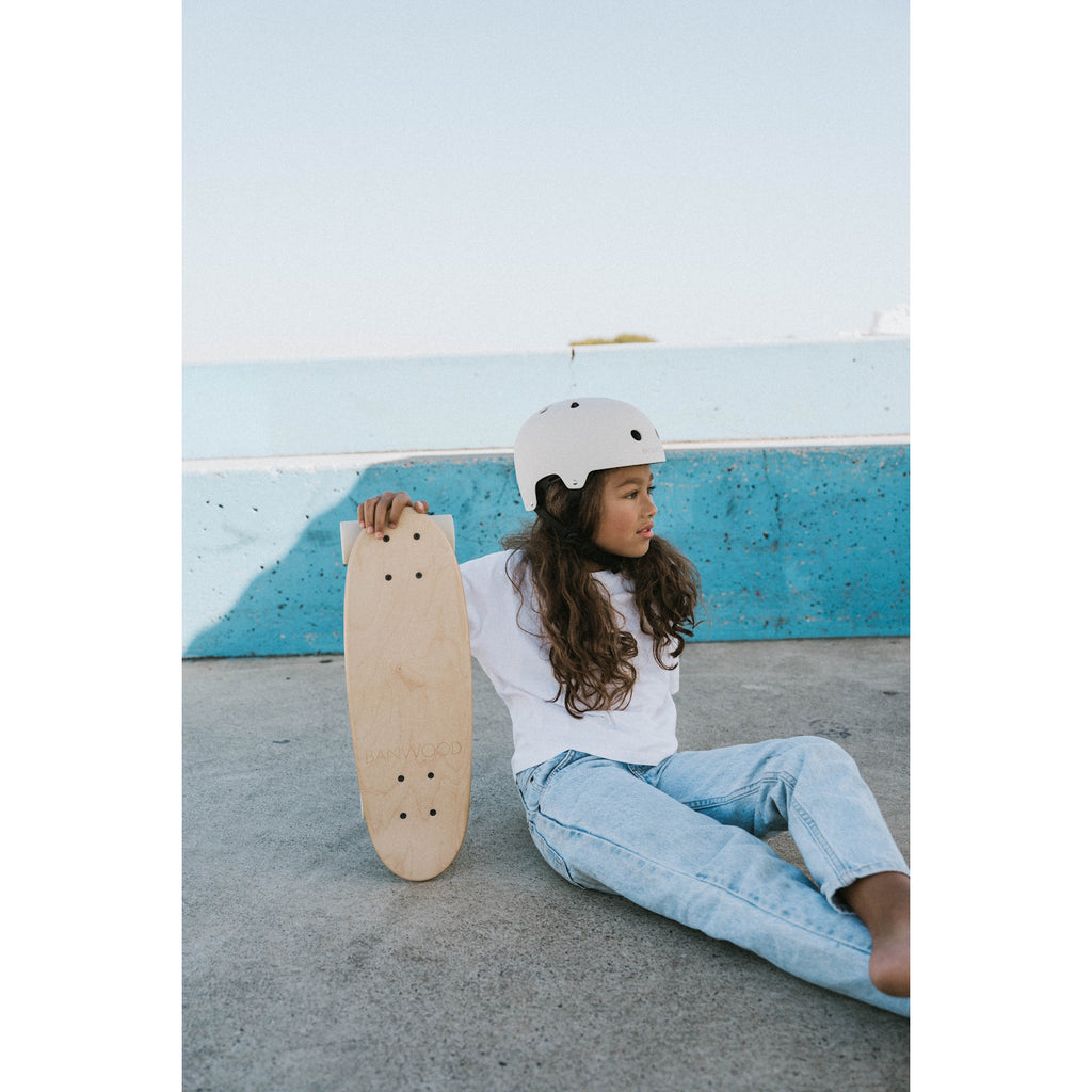 A minimalist cruiser skateboard with a natural wood finish, soft wheels, and a classic design, perfect for young riders and smooth cruising.