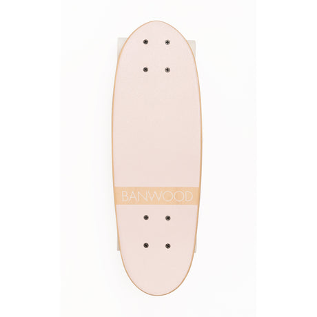 A vintage-inspired cruiser skateboard featuring a pastel pink deck, soft wheels, and a durable maple wood finish, perfect for young beginners.
