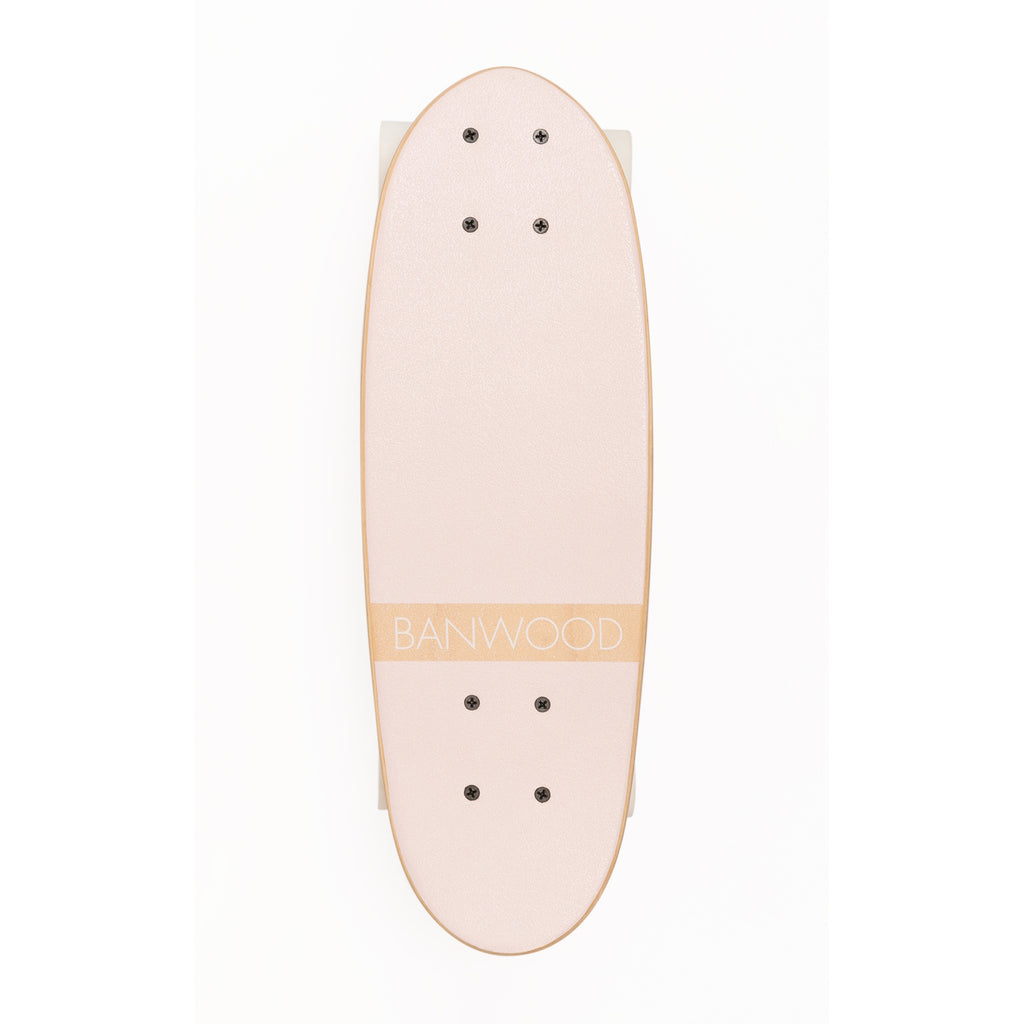 A vintage-inspired cruiser skateboard featuring a pastel pink deck, soft wheels, and a durable maple wood finish, perfect for young beginners.