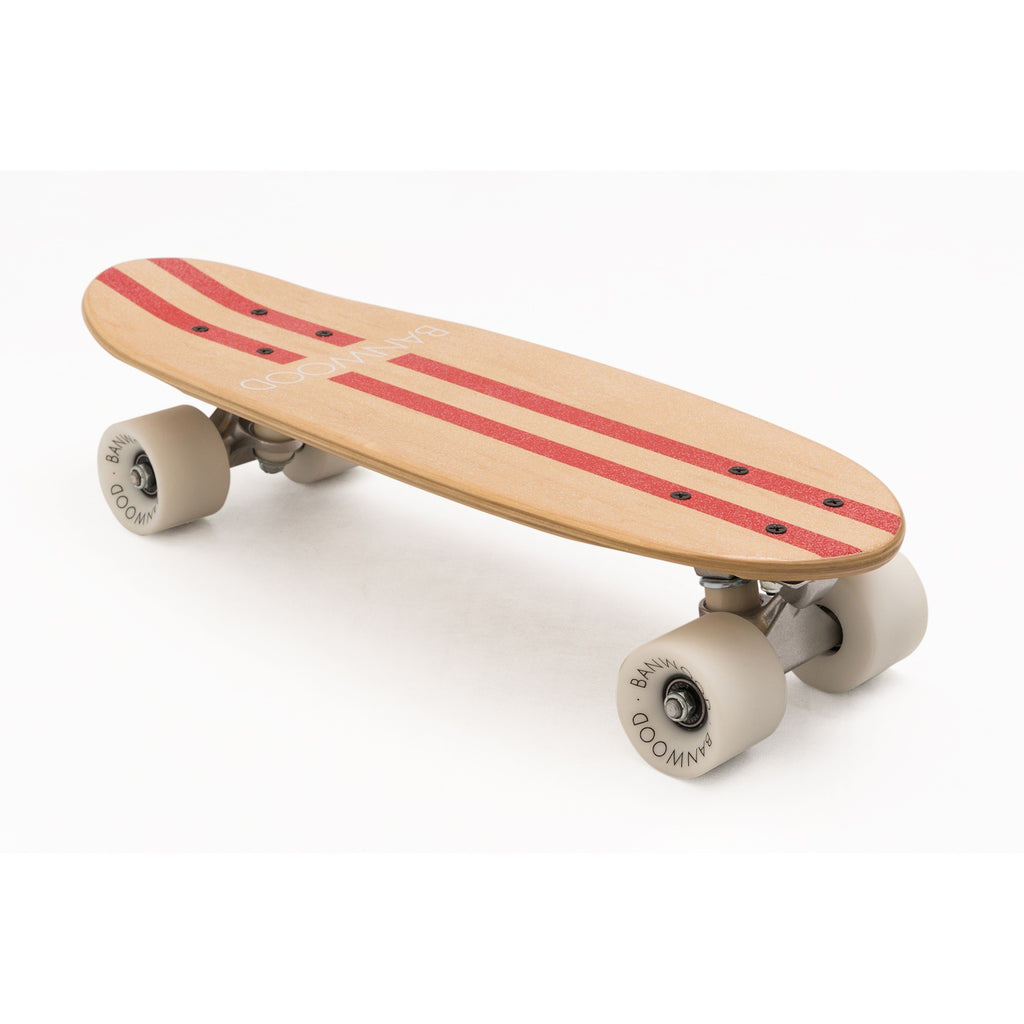 A retro-style cruiser skateboard with a bold red deck, soft wheels, and a sturdy maple wood construction, designed for smooth rides and young skaters.