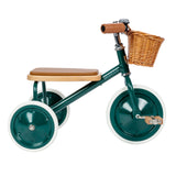 Banwood dark green vintage tricycle in profile view, featuring a wicker basket and oak wooden seat.