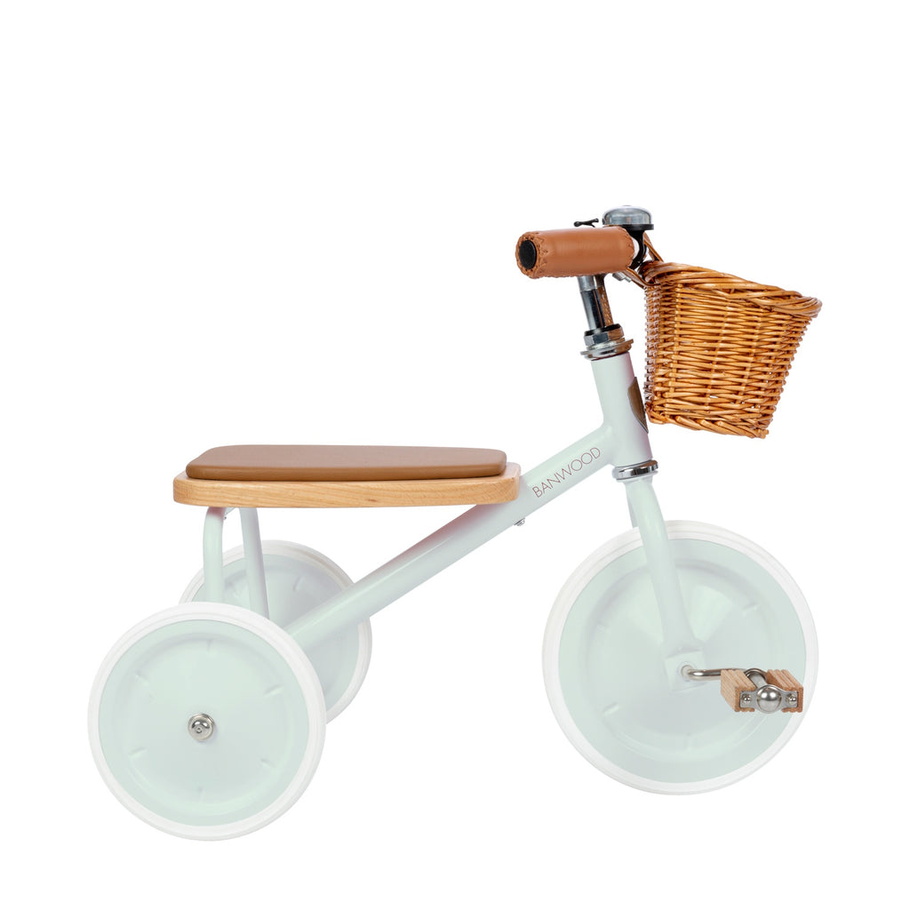 A vintage-inspired children's tricycle in a soft mint green, featuring a sturdy steel frame, wooden pedals, a removable push bar, and a wicker basket.