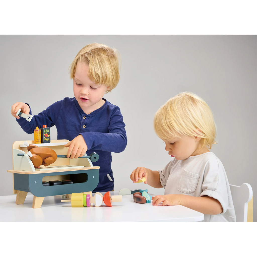 Featuring a wooden BBQ grill with pretend food, utensils, and accessories for kids to enjoy imaginative outdoor cooking play.