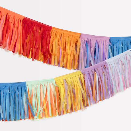 Close-up of a colorful rainbow fringe garland draped against a white background.