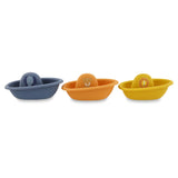 Three colorful plastic toy boats lined up, featuring an elephant, a fox, and a lion on the cabins.