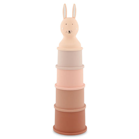 Stack of five pastel-colored toy cylinders topped with a smiling rabbit head. The colors range from light pink to brown, creating a playful, gentle tone.