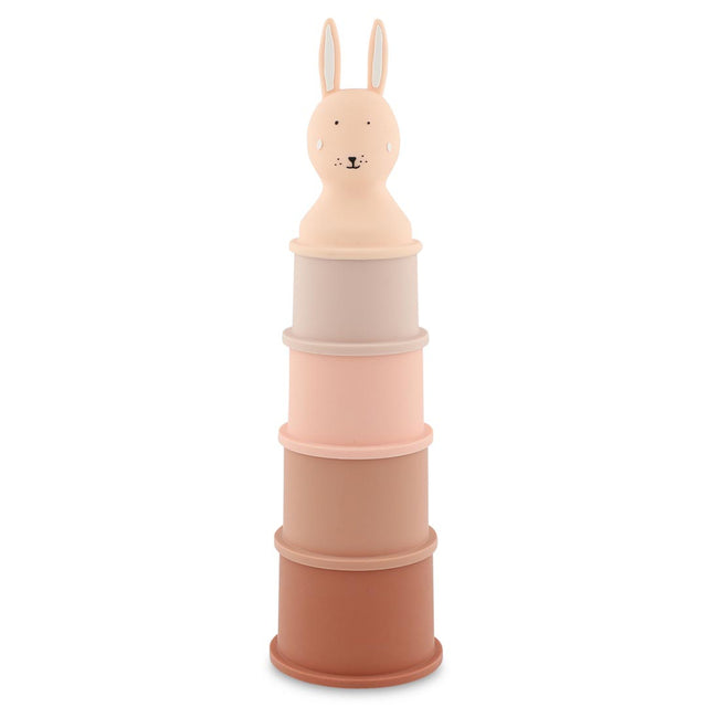 Stack of five pastel-colored toy cylinders topped with a smiling rabbit head. The colors range from light pink to brown, creating a playful, gentle tone.